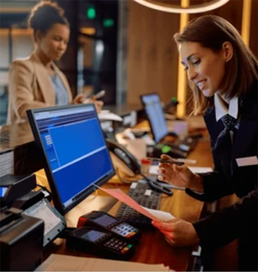 Hotel front desk staff assisting a guest at check-in